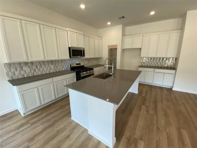 a kitchen with stainless steel appliances a refrigerator sink and cabinets