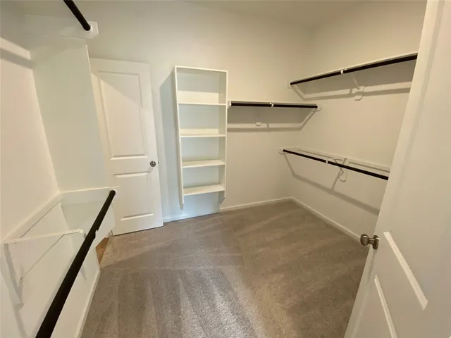 a view of walk in closet with empty racks