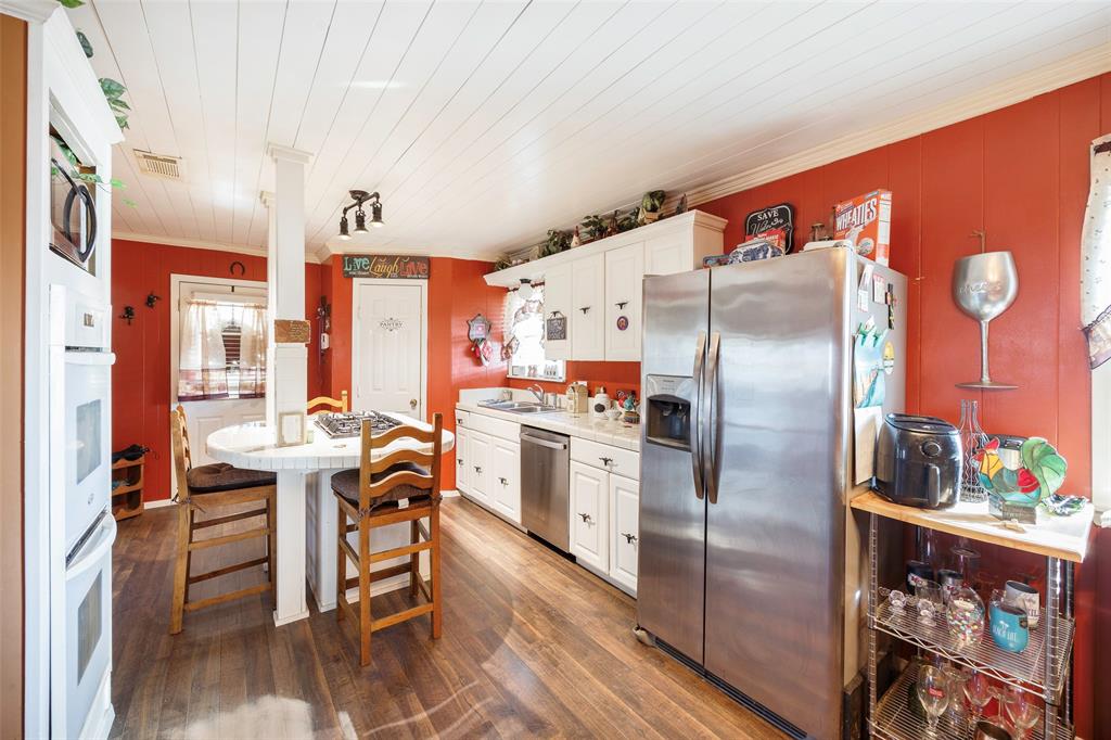 717 Houston Street Anna, TX 75409 - Photo 4 of 25 a kitchen with stainless steel appliances a refrigerator and a stove top oven