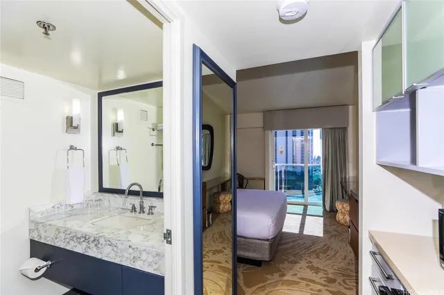 a bathroom with a granite countertop sink a large mirror a toilet and a shower