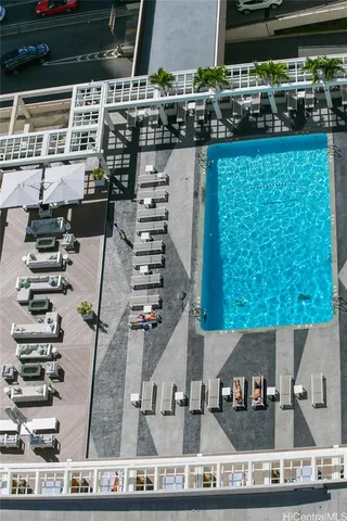a view of an empty room with wooden floor and windows