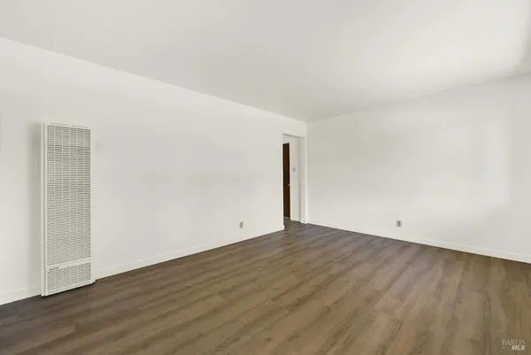 a kitchen with stainless steel appliances granite countertop a sink a stove a microwave a sink and white cabinets with wooden floor