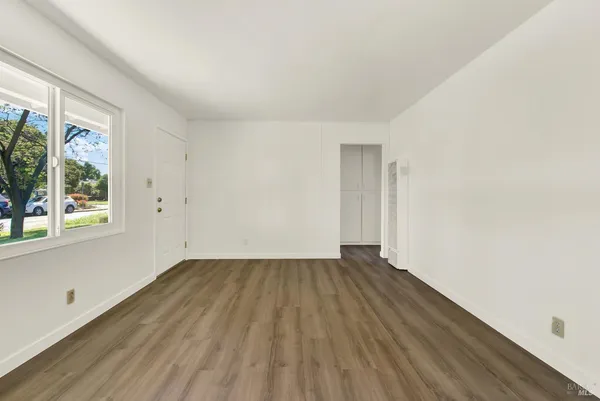 a view of an empty room with wooden floor