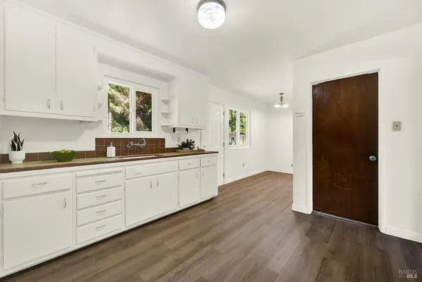 a view of a kitchen with wooden floor and a sink
