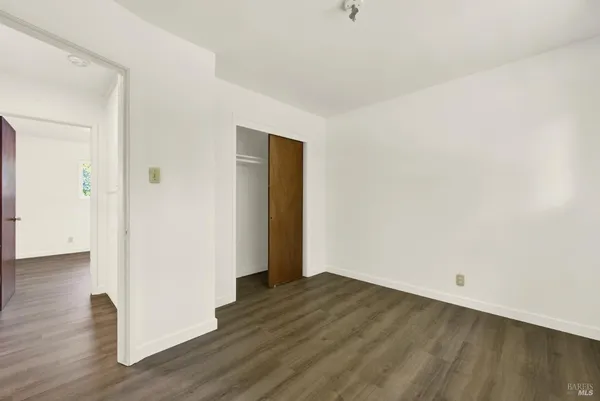 an empty room with wooden floor and painting on the wall