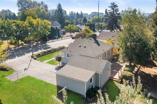 an aerial view of a house with swimming pool and large trees