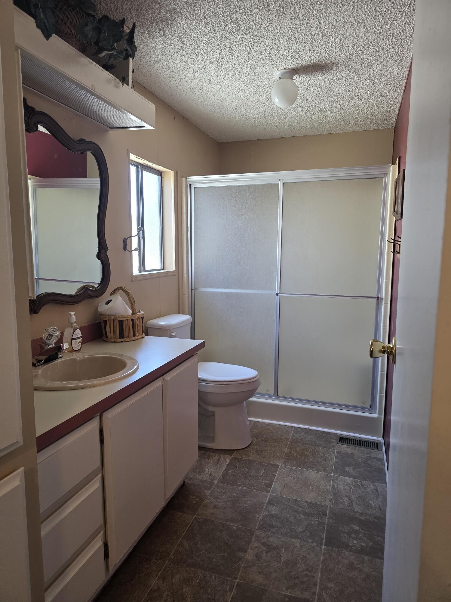 10595 Hot Mineral Spa Road, Unit 228 Niland, CA 92257 - Photo 22 of 38 a bathroom with a toilet a sink a mirror and shower