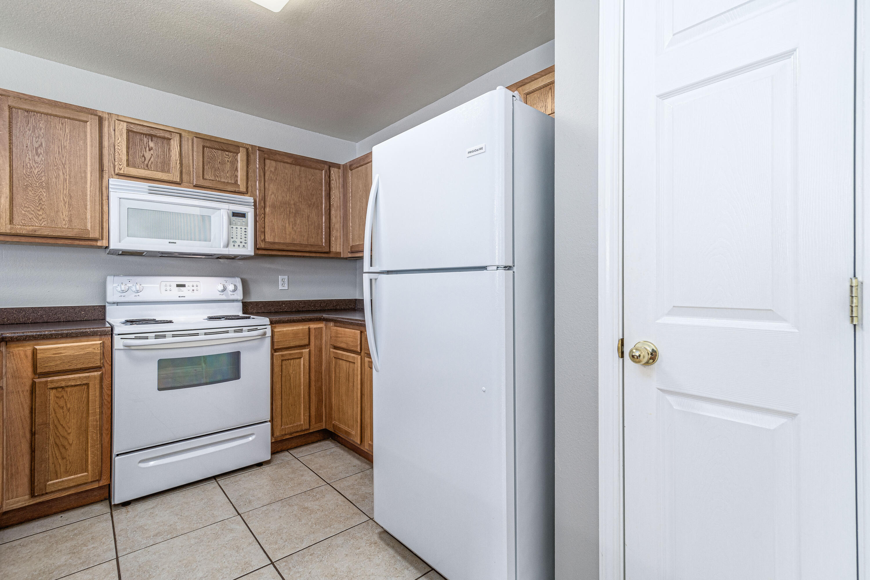 100 Corwin Drive, Unit 100 Crestview, FL 32539 - Photo 8 of 30 a white refrigerator freezer and a stove top oven