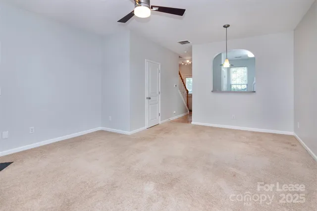 en empty room with windows and ceiling fan