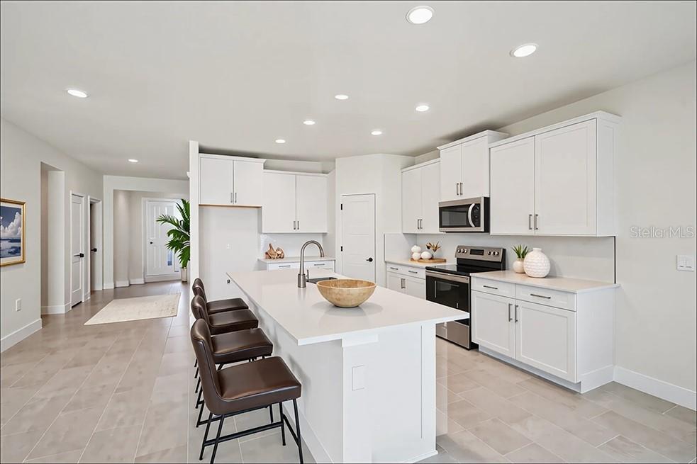 4224 Southwest 52nd Lane Road Ocala, FL 34474 - Photo 2 of 24 a kitchen with white cabinets and stainless steel appliances