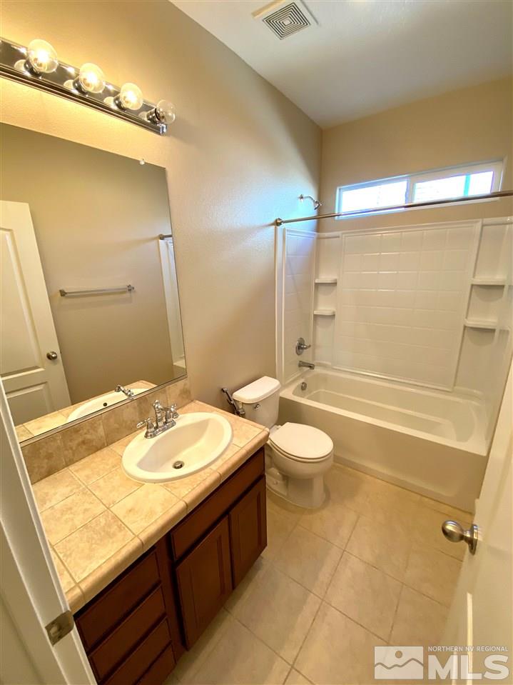 445 Pesaro Way Reno, NV 89521 - Photo 13 of 24 a bathroom with a granite countertop sink toilet a large mirror and shower