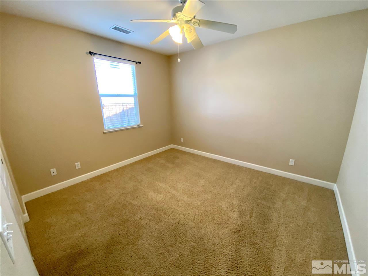 445 Pesaro Way Reno, NV 89521 - Photo 14 of 24 an empty room with a window and a ceiling fan