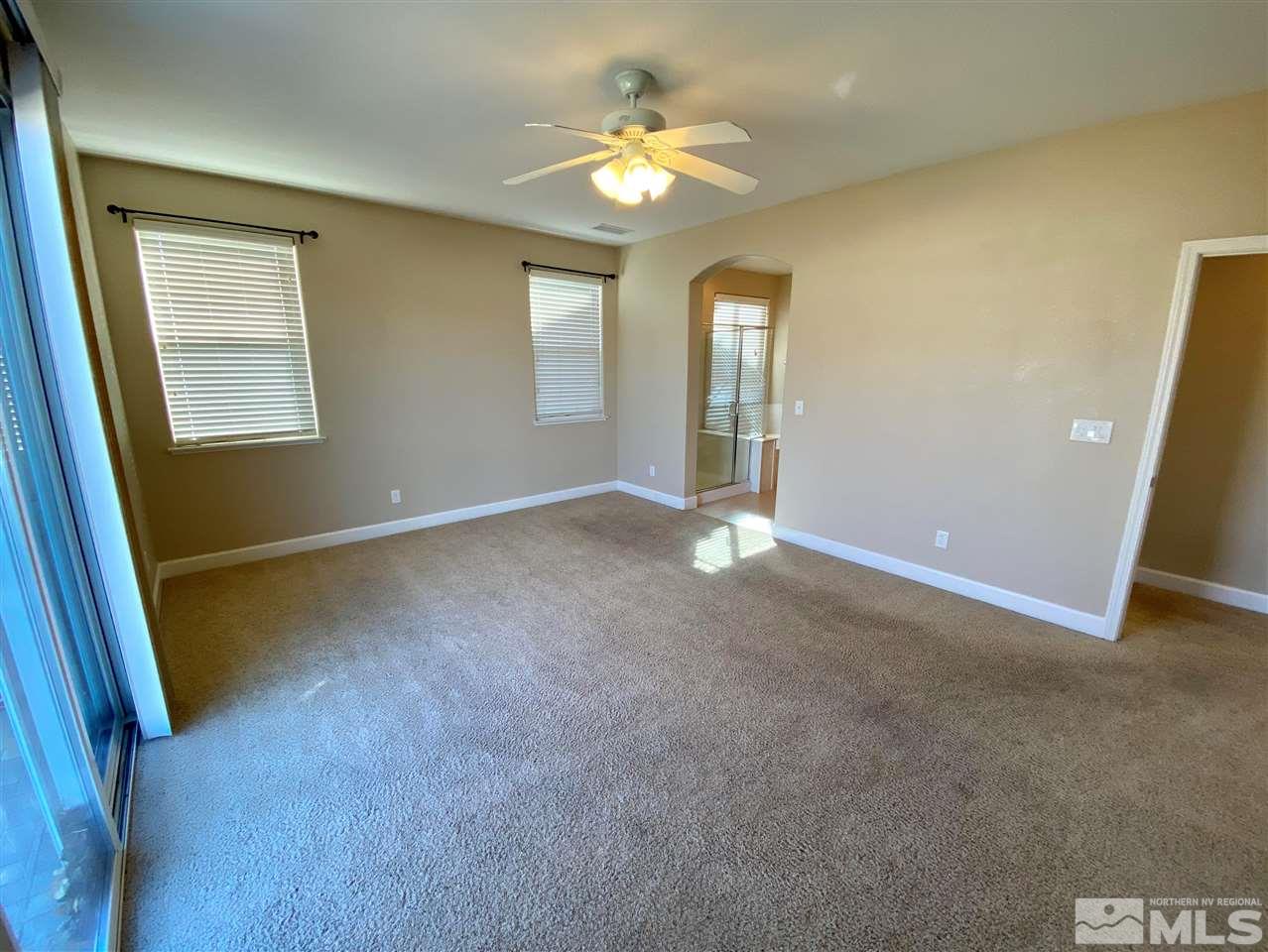 445 Pesaro Way Reno, NV 89521 - Photo 8 of 24 an empty room with chandelier fan and windows