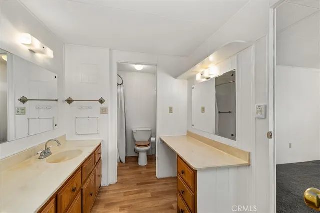 a bathroom with a sink a toilet a mirror and shower