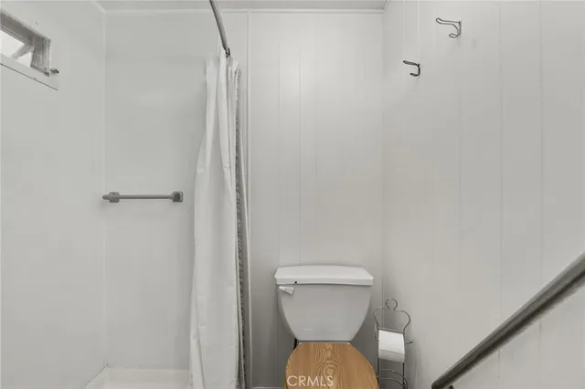 a bathroom with a toilet and a shower