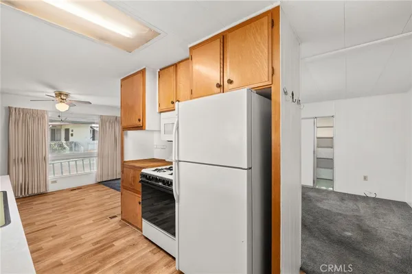 a white refrigerator freezer and a wooden floor