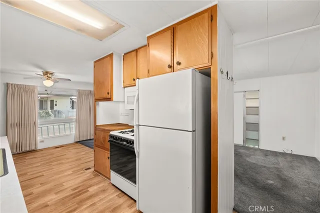 a white refrigerator freezer and a wooden floor