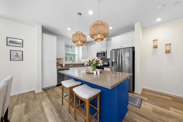 a kitchen with stainless steel appliances granite countertop a table chairs and a refrigerator
