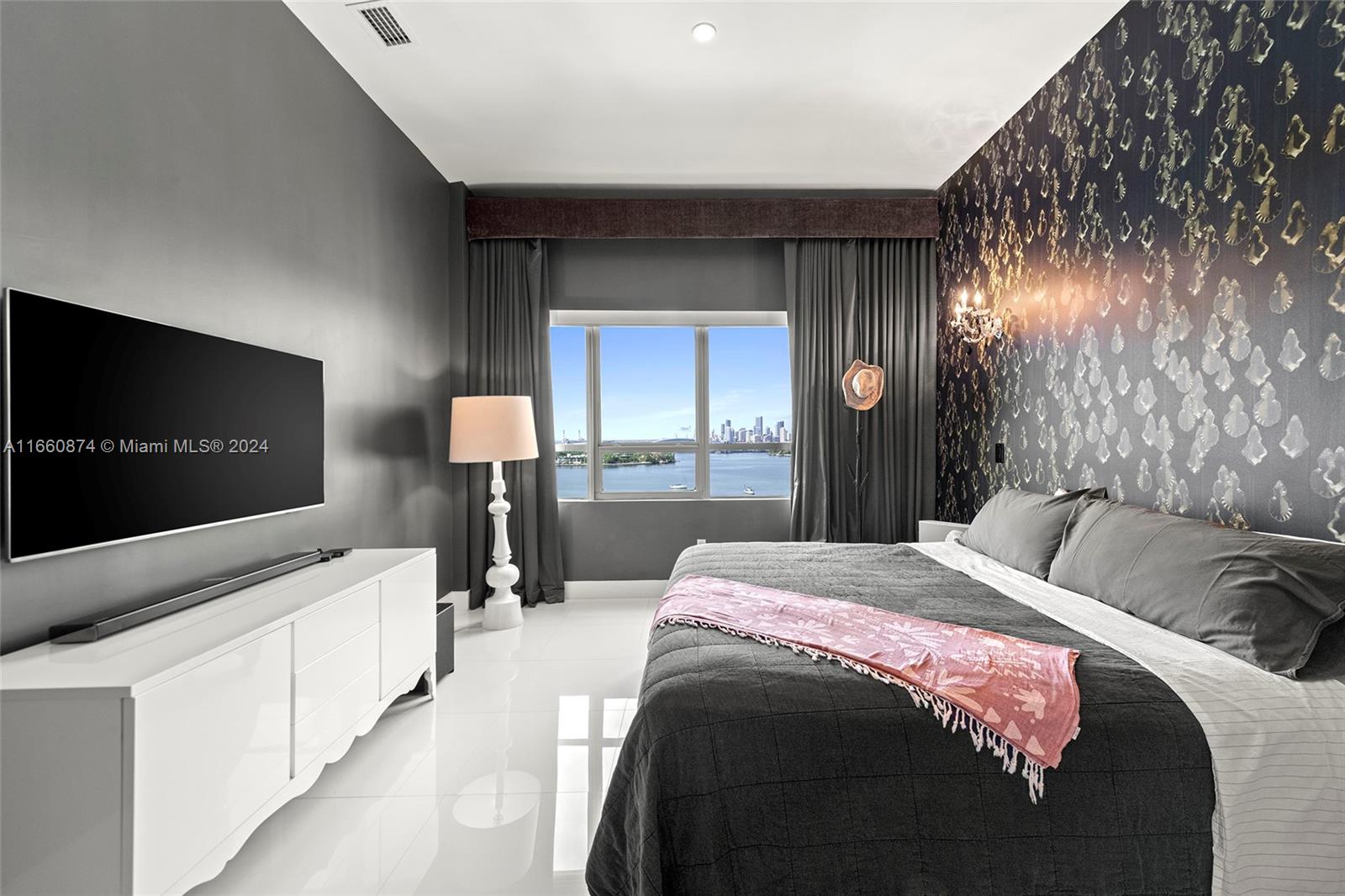 1500 Bay Road, Unit 1524S Miami Beach, FL 33139 - Photo 12 of 40 a bedroom with a bed and a flat tv screen on dresser