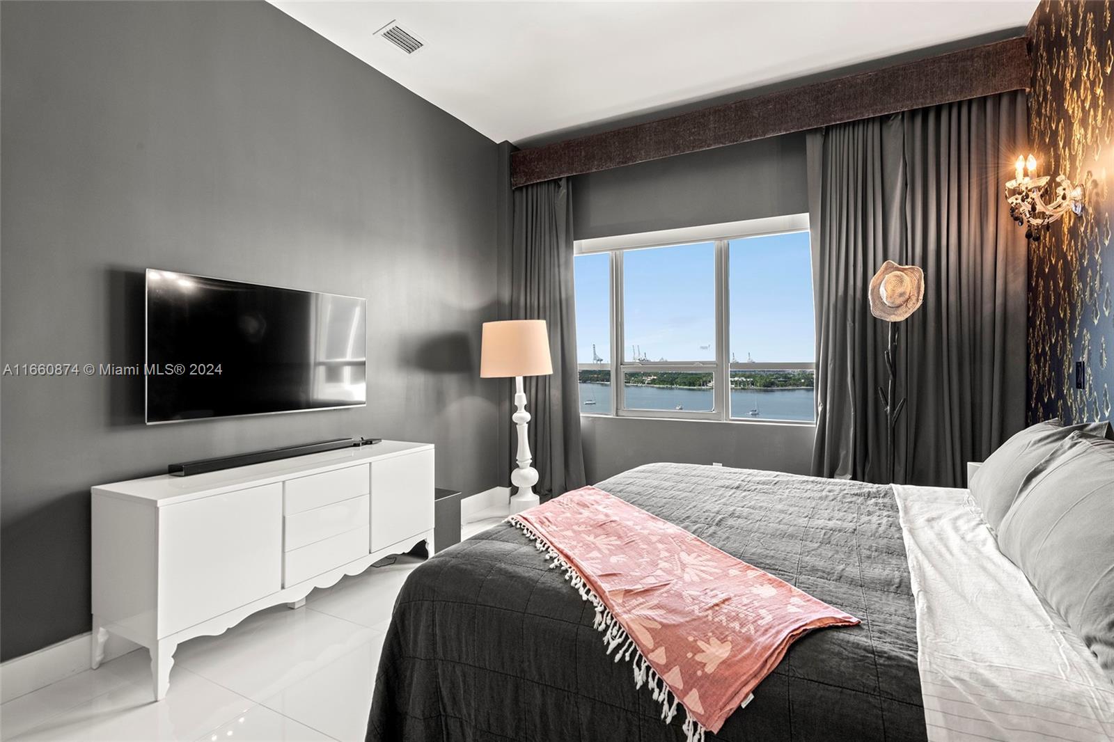 1500 Bay Road, Unit 1524S Miami Beach, FL 33139 - Photo 13 of 40 a bedroom with a bed and a flat screen tv