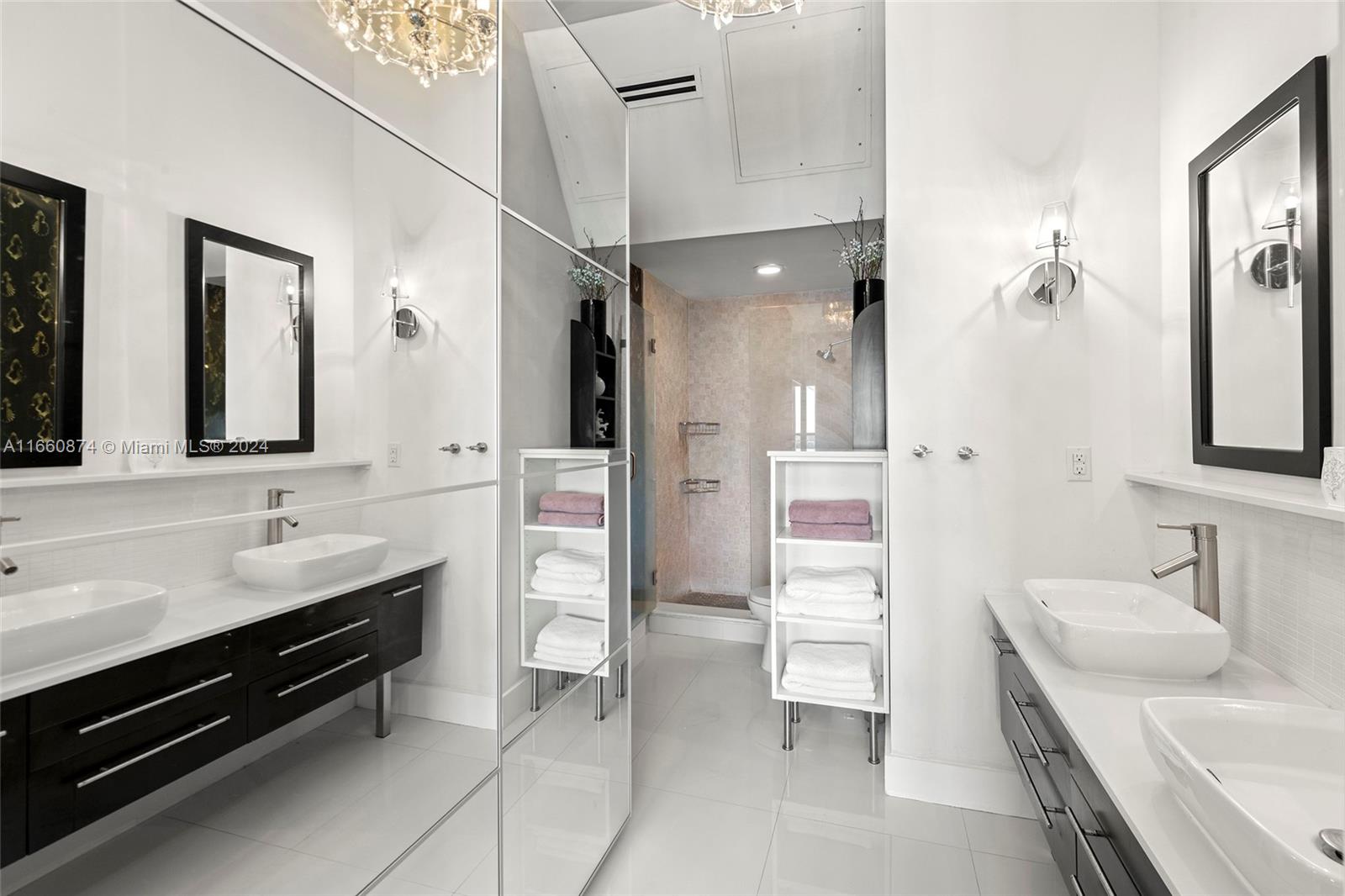 1500 Bay Road, Unit 1524S Miami Beach, FL 33139 - Photo 15 of 40 a bathroom with a double vanity sink a mirror and a shower