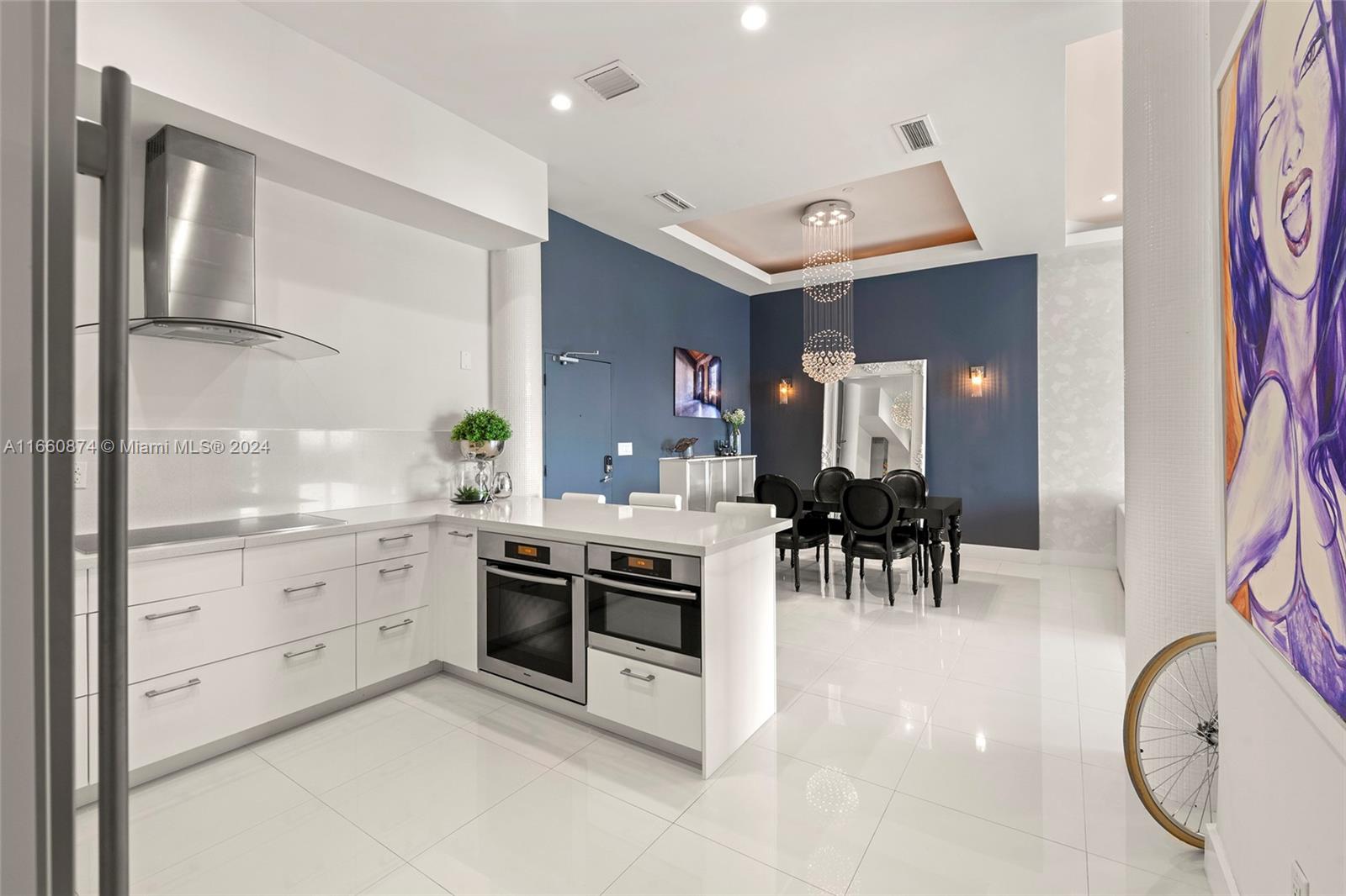 1500 Bay Road, Unit 1524S Miami Beach, FL 33139 - Photo 10 of 40 a kitchen with white cabinets and stainless steel appliances