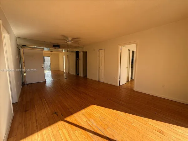 a view of empty room with wooden floor