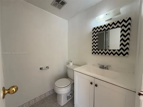 a bathroom with a sink mirror vanity and toilet