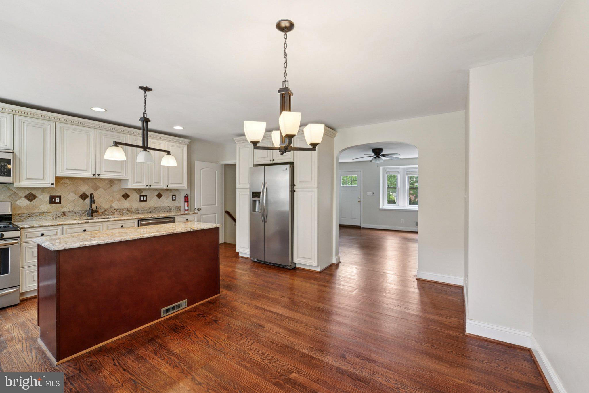 190 Dumbarton Road Baltimore, MD 21212 - Photo 8 of 24 a kitchen with stainless steel appliances granite countertop a refrigerator a stove top oven a sink dishwasher and a dining table with wooden floor