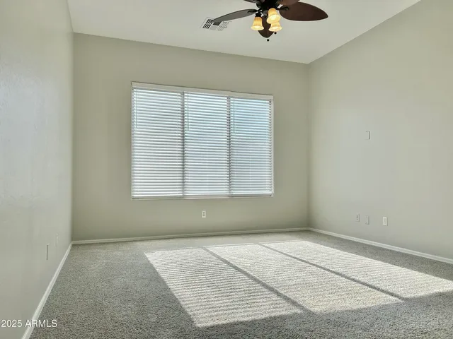 an empty room with a window and a ceiling fan