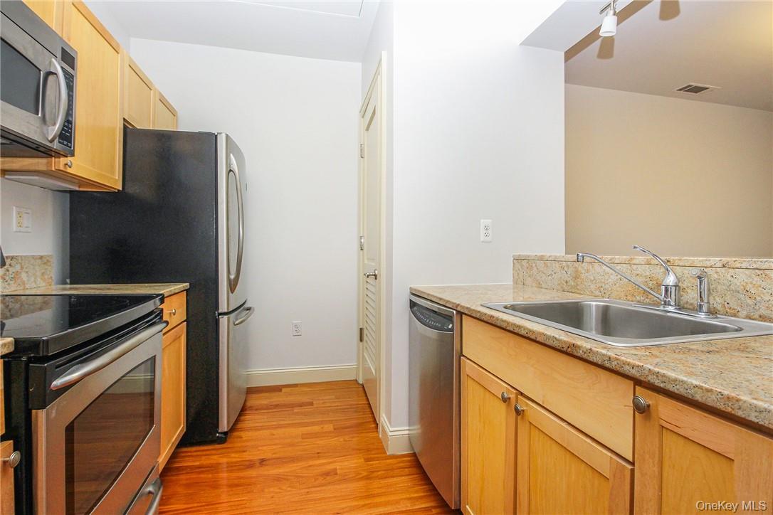 543 Main Street, Unit 211 New Rochelle, NY 10801 - Photo 12 of 22 a kitchen with a sink and a refrigerator