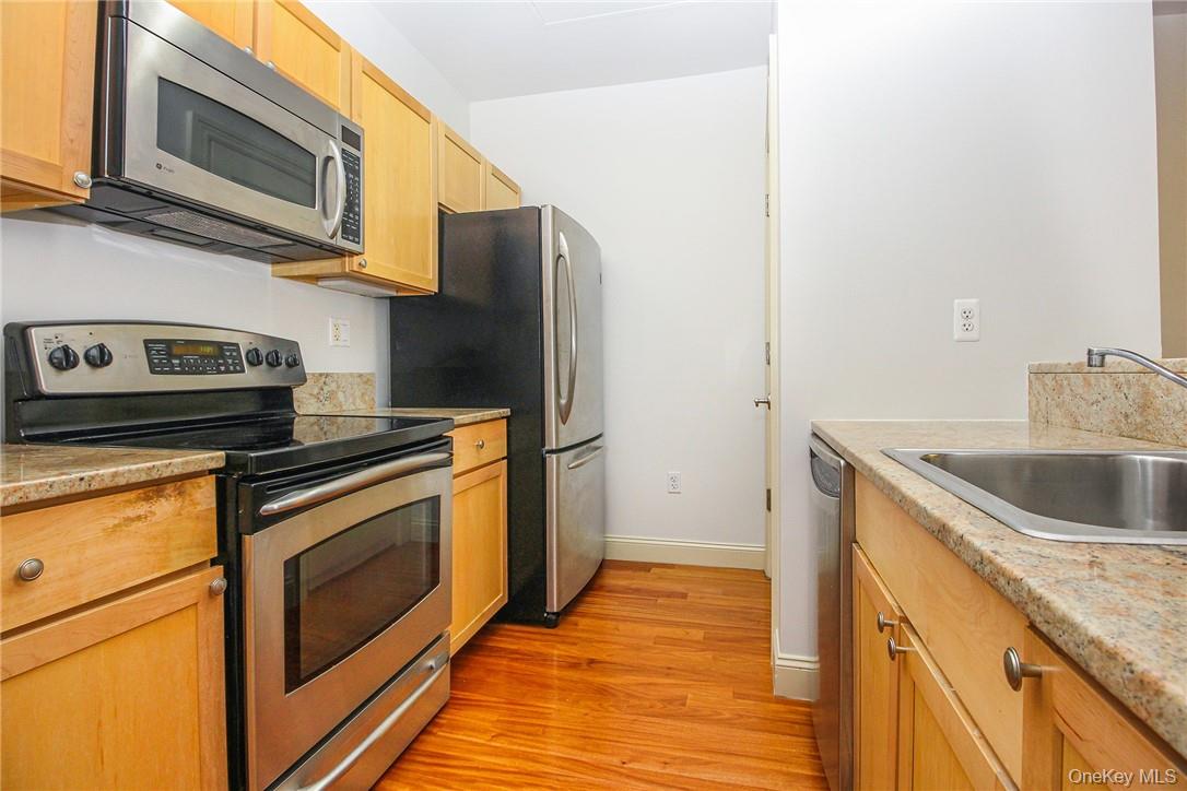 543 Main Street, Unit 211 New Rochelle, NY 10801 - Photo 13 of 22 a kitchen with stainless steel appliances granite countertop a sink stove and refrigerator