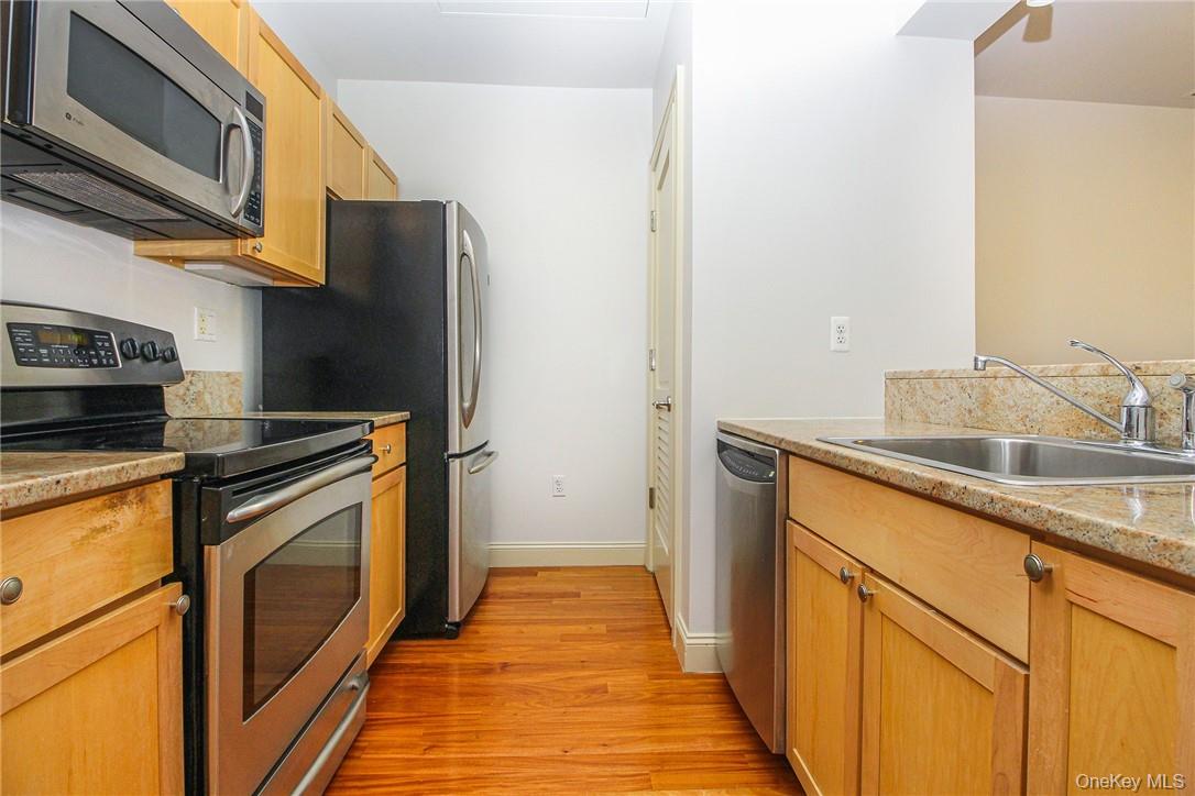 543 Main Street, Unit 211 New Rochelle, NY 10801 - Photo 14 of 22 a kitchen with a sink and a refrigerator