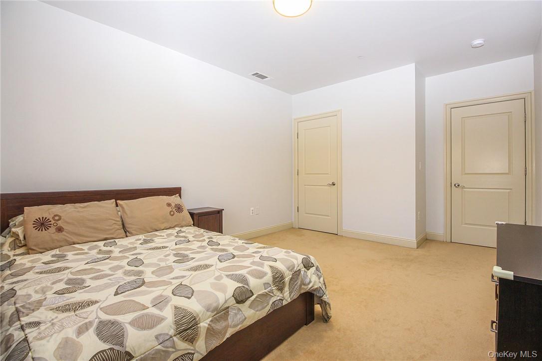 543 Main Street, Unit 211 New Rochelle, NY 10801 - Photo 16 of 22 a bedroom with a bed and flat screen tv