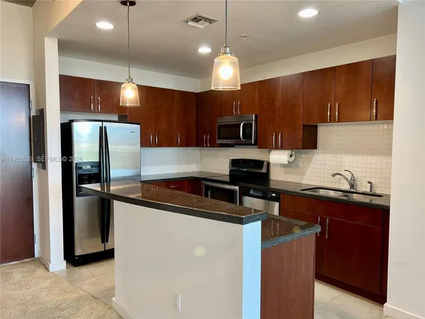 a kitchen with a refrigerator a sink a stove a microwave and cabinets