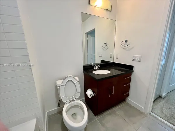 a white toilet and tub sitting next to a bathroom sink