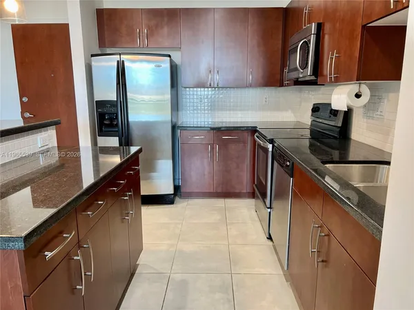 a kitchen with stainless steel appliances granite countertop a refrigerator and a stove