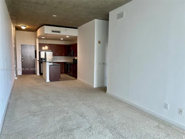 a view of a kitchen with a sink and an empty room