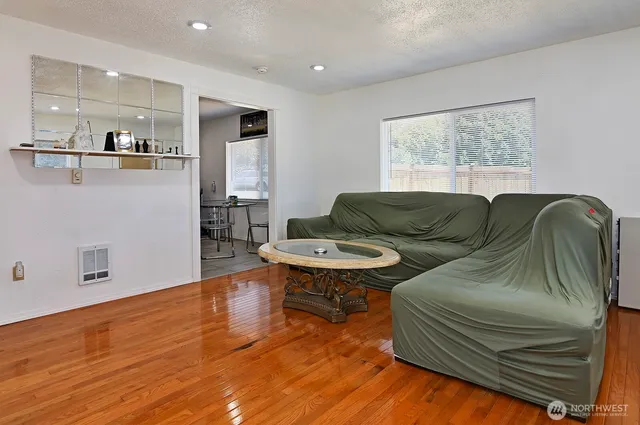 a living room with furniture and a wooden floor