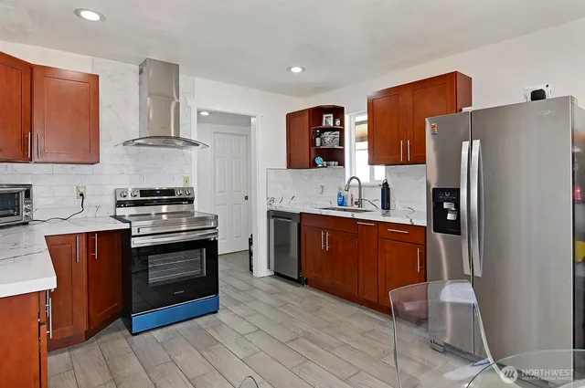 a kitchen with stainless steel appliances granite countertop a refrigerator stove and sink