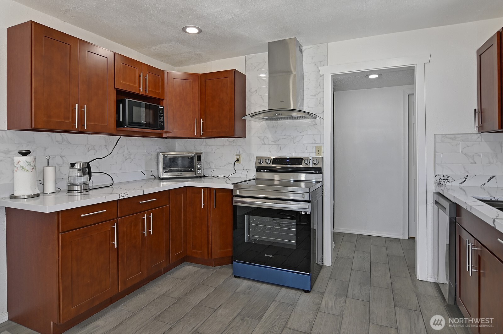 7660 South 126th Street Seattle, WA 98178 - Photo 16 of 33 a kitchen with stainless steel appliances granite countertop a stove sink and cabinets
