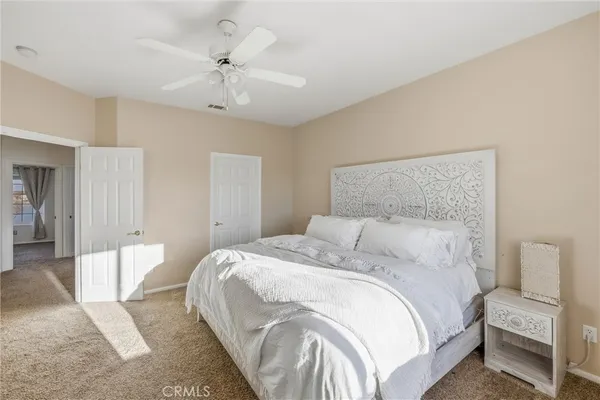 a bedroom with a bed and a ceiling fan