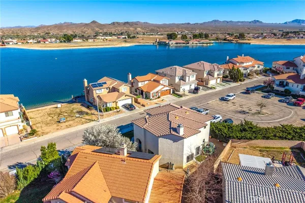an aerial view of a house with a lake