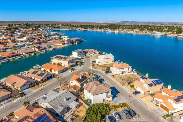 an aerial view of a house with a swimming pool yard and lake view in back