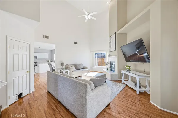 a living room with furniture a flat screen tv and a wooden floor