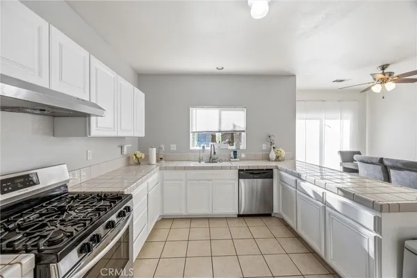 a kitchen with a sink stove top oven and cabinets