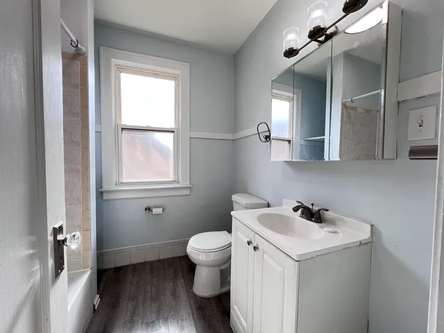 a bathroom with a toilet sink and mirror