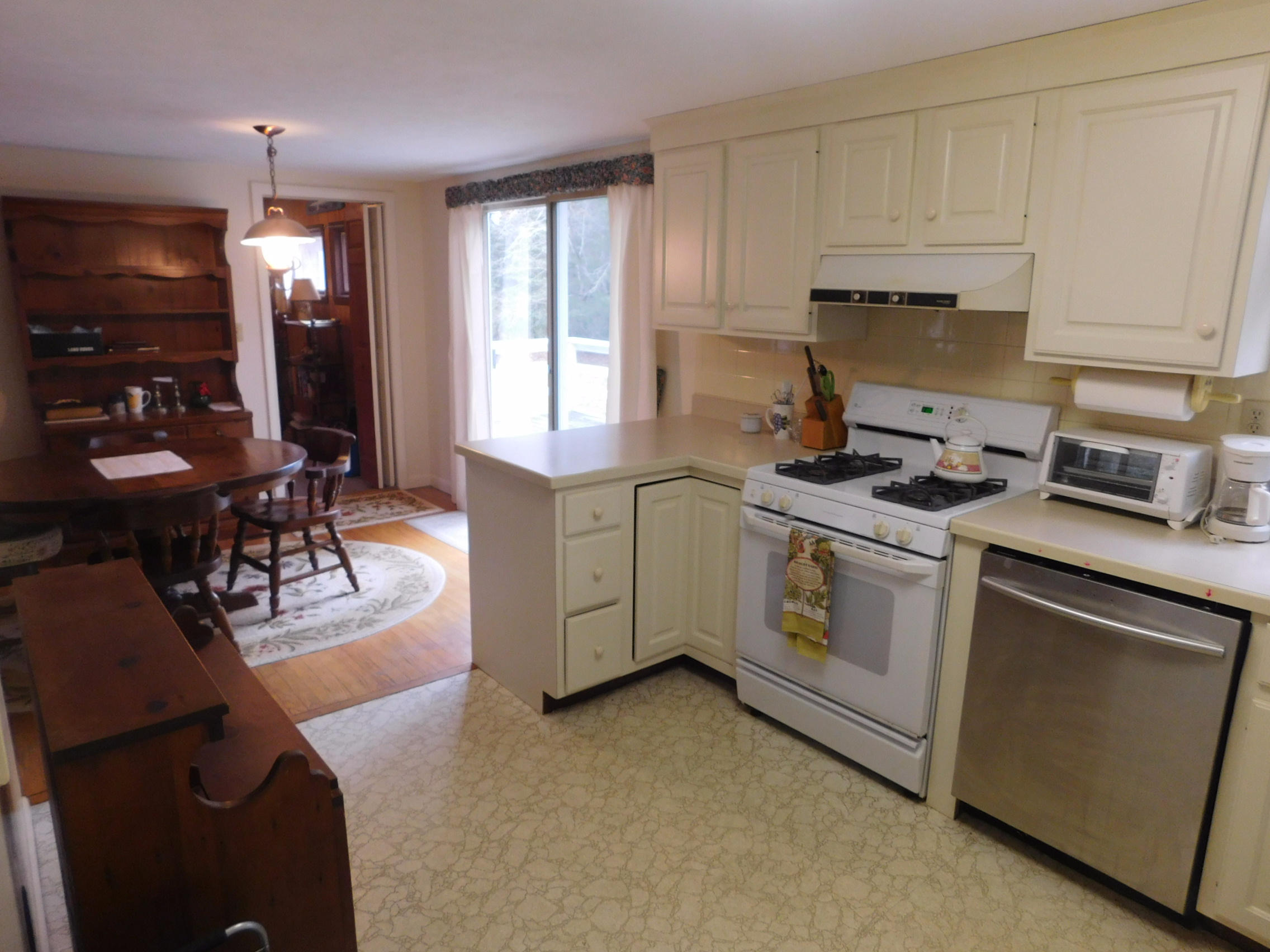 202 Woodside Road West Barnstable, MA 02668 - Photo 6 of 21 a kitchen with cabinets appliances and a dining table