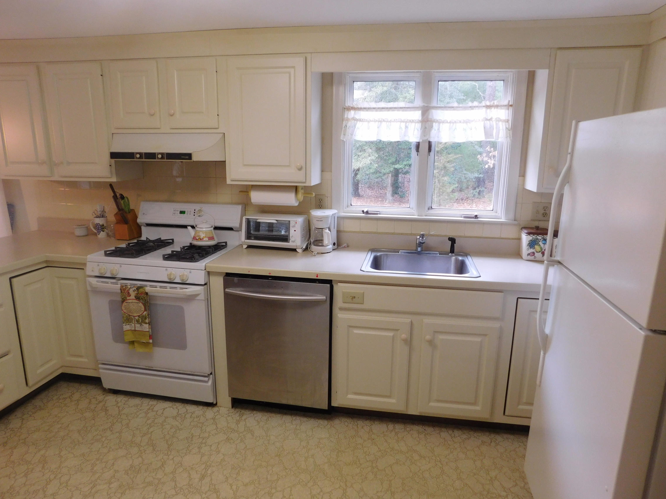 202 Woodside Road West Barnstable, MA 02668 - Photo 7 of 21 a kitchen with granite countertop white cabinets sink and white appliances