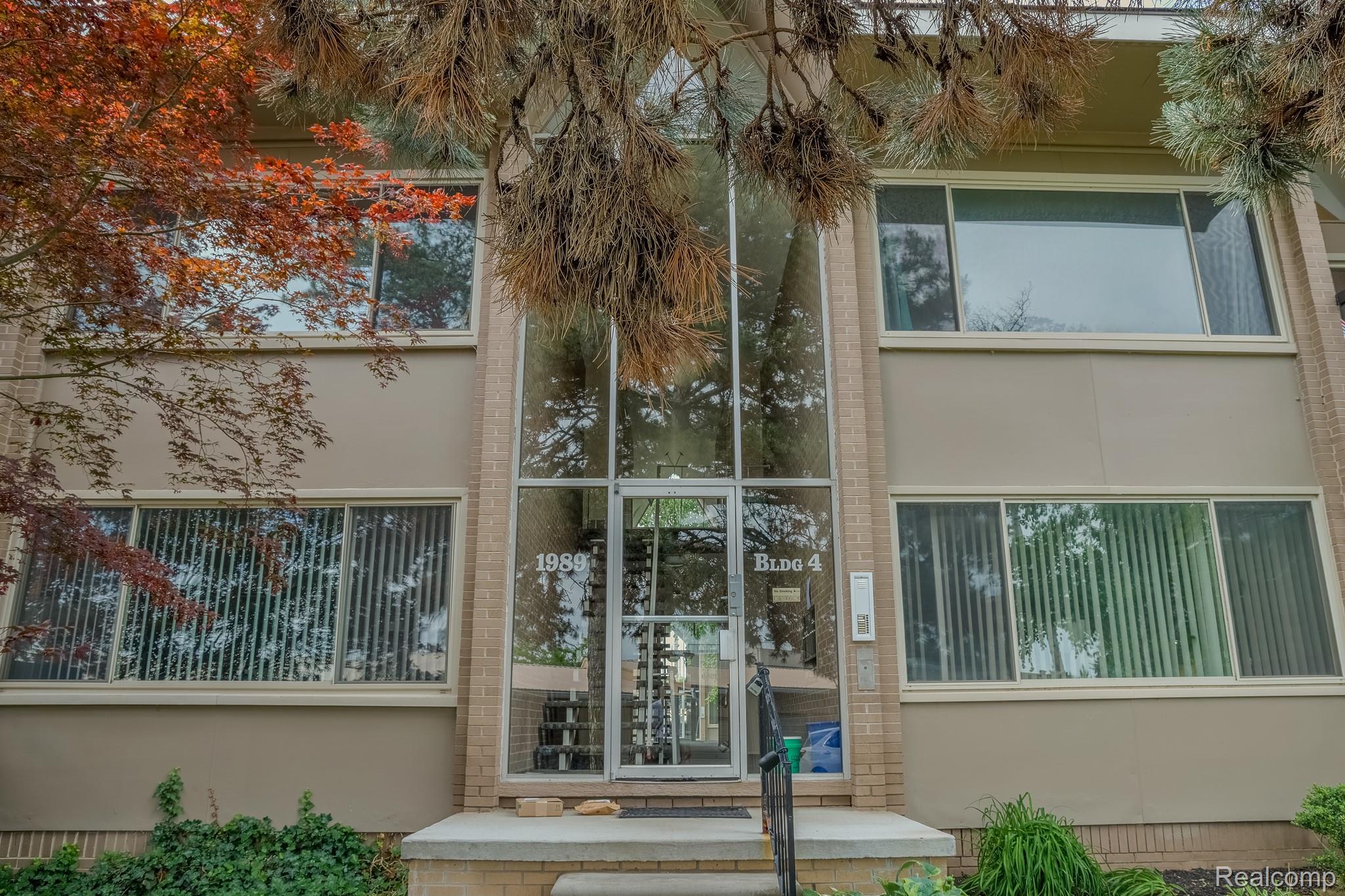 1989 Klingensmith Road, Unit 46 Bloomfield Hills, MI 48302 - Photo 36 of 41 Multi-story building facade featuring a glass entry system with a prominent numerical address